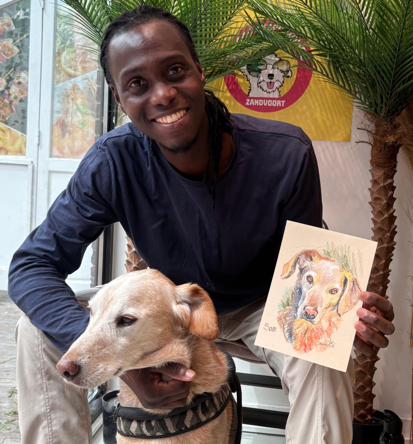 Solomon Kasumba met een hond in zijn armen